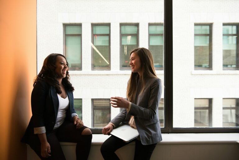 Deux femmes échangent près d'une fenêtre lors d'un entretien d'accompagnement